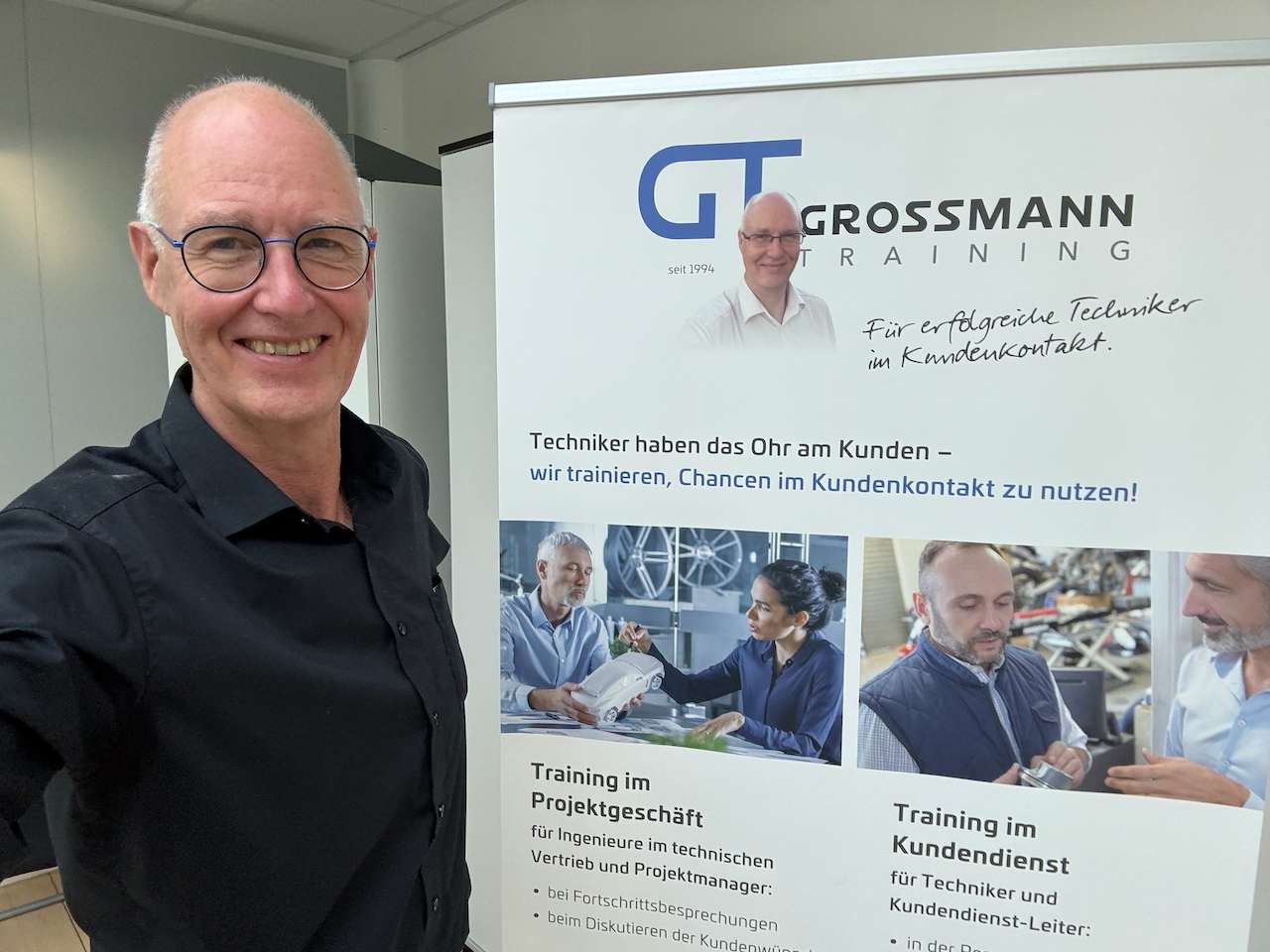 Bernd Grossmann vor dem Grossmann Training Firmenbanner